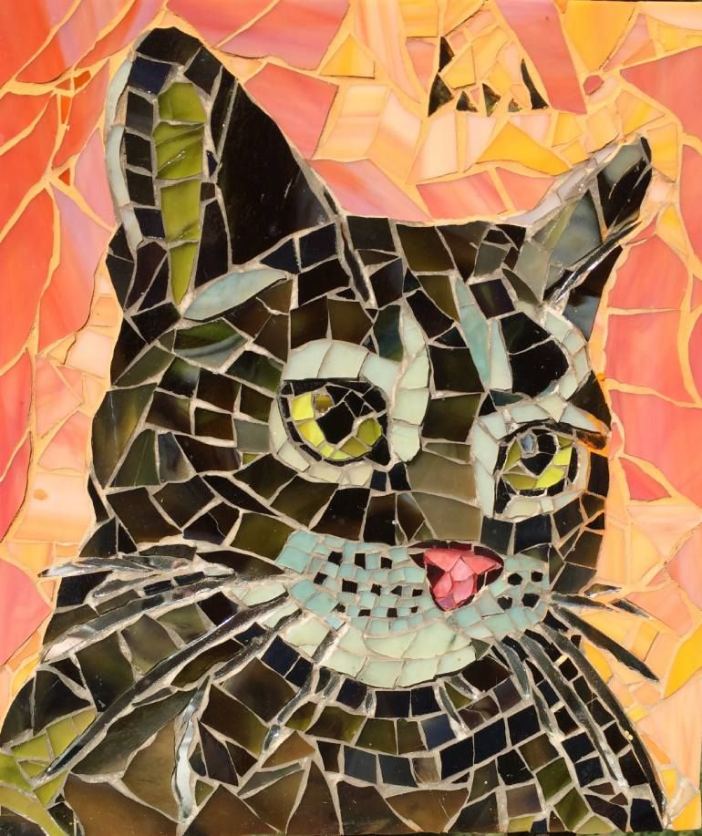 A mosaic art piece of a brown cat with yellow eyes